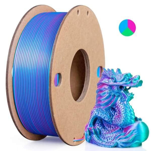 A spool of filament with blue and pink stripes beside a colourful dragon figurine.