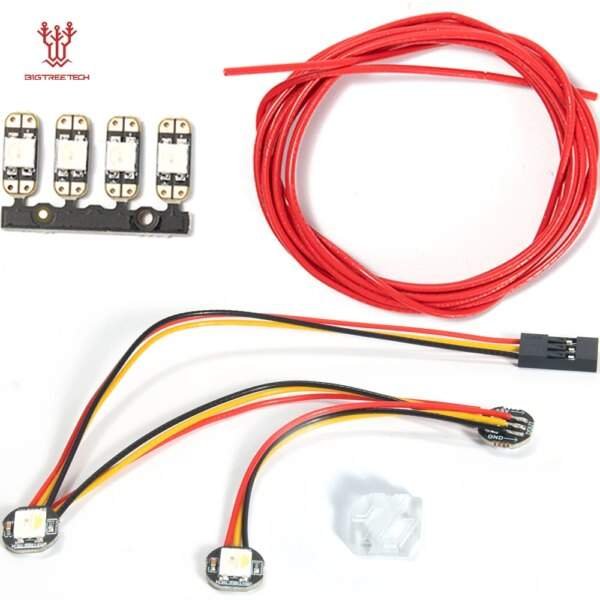 A collection of electronic components including a strip of red wire, a connection block with three LED lights, a small connector with multiple wires (red, black, yellow), and a rectangular plastic piece.