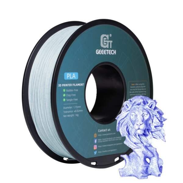A spindle of GEEETECH 3D printer filament in light blue, labelled as PLA, with specifications for diameter and features like bubble-free and tangle-free. Next to it is a small blue 3D printed lion statue.