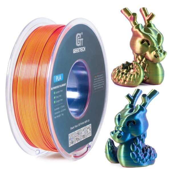 A spool of multicoloured 3D printer filament, labelled "PLA," with orange and red colours, next to two small, intricately designed dragon figurines in vibrant colours.