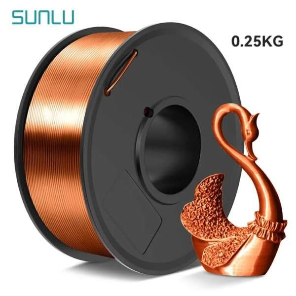 A spool of copper-coloured 3D printing filament with a weight of 0.25 kg, alongside a small, intricately designed swan figurine made from the same material.
