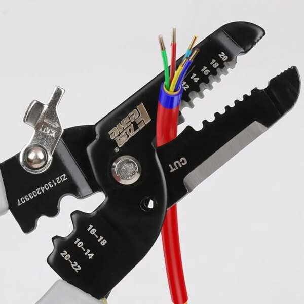 A pair of wire stripping pliers is shown with several coloured wires (red, green, blue) positioned in the cutting section, featuring engraved size markings on the tool.
